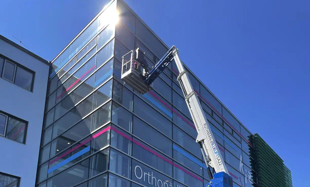 Fensterreinigung mit Hubarbeitsbühne an einer großen Glasfassade