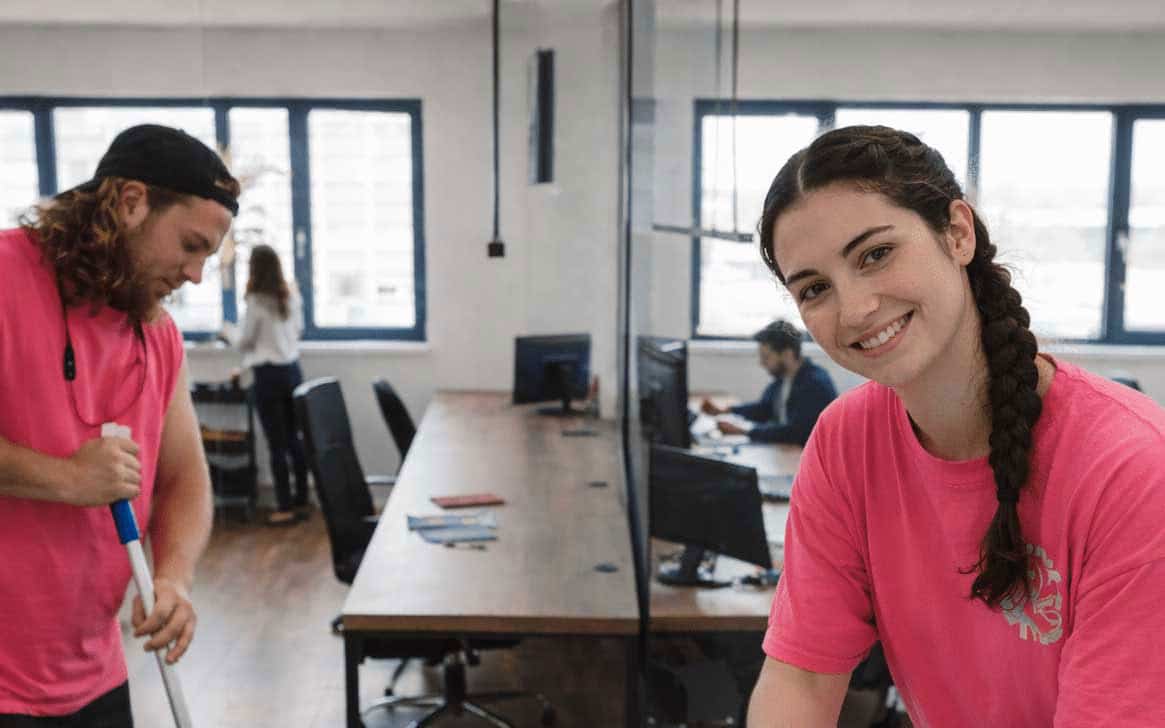 Reinigungsteam in pinken Shirts bei der Büroreinigung