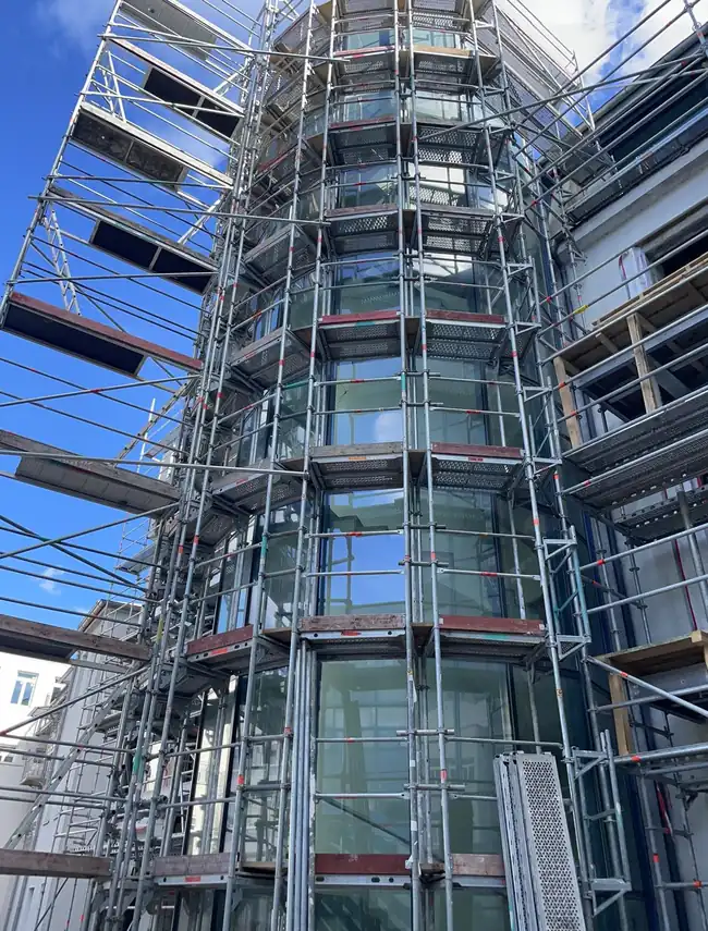 Mehrgeschossige Glasfassade mit Gerüst beim Reinigungseinsatz in Rosenheim