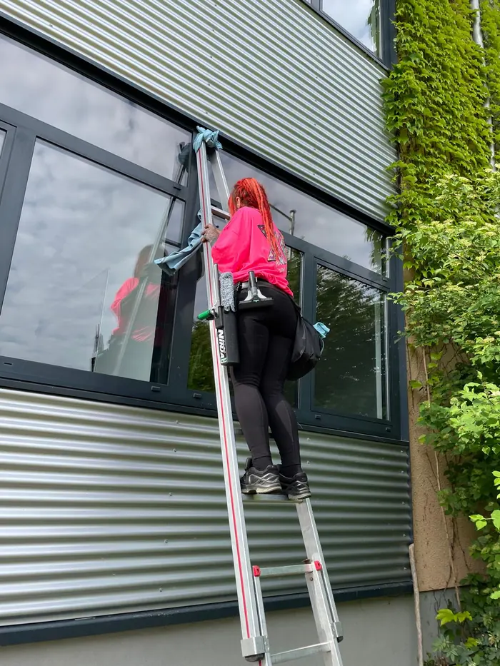 Mitarbeiterin bei der Fensterreinigung am LKZ Prien