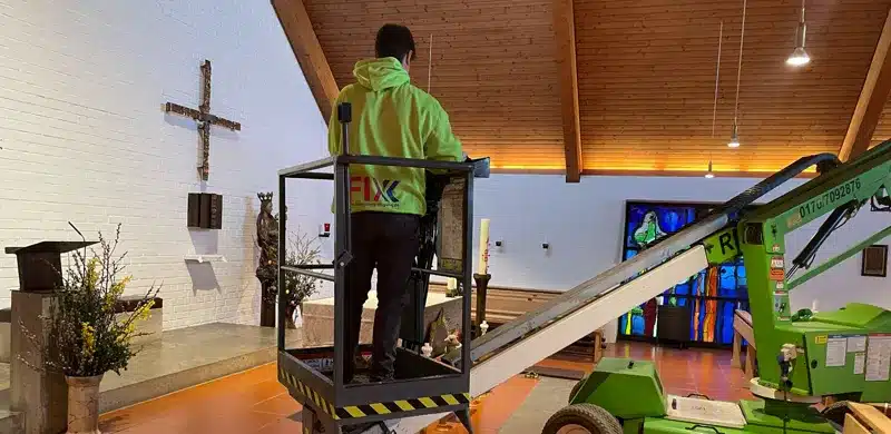 Mitarbeiter von Fix Fensterreinigung auf der Hubarbeitsbühne im Kirchenraum