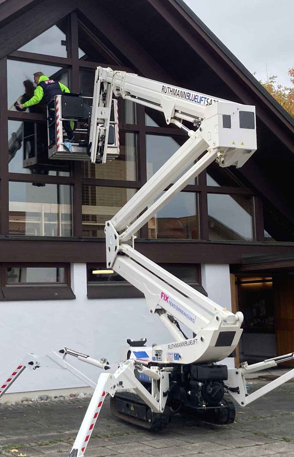FIX-Mitarbeiter reinigt die äußeren Kirchenfenster vom Arbeitskorb aus